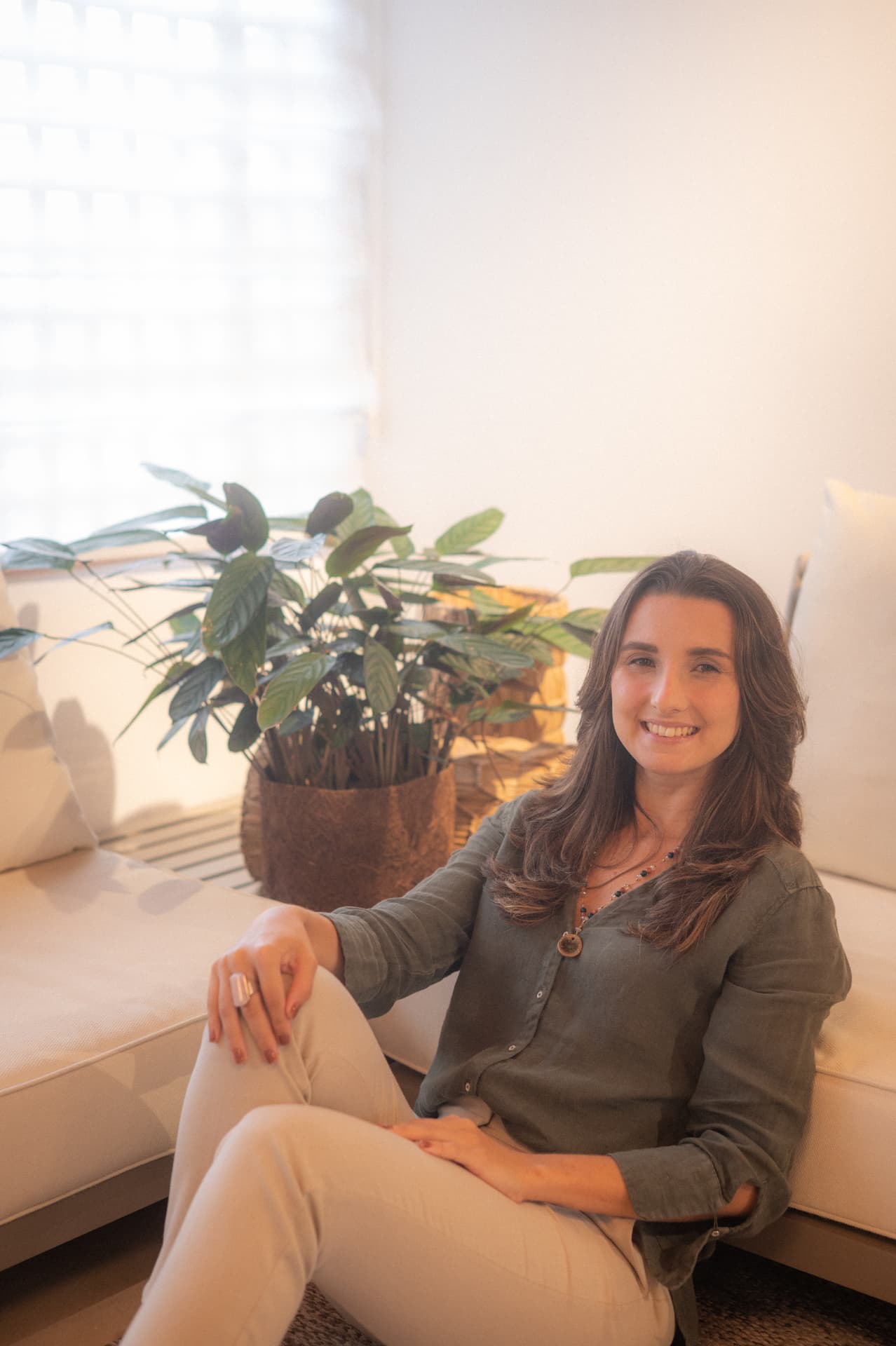 Nutricionista sorrindo em uma sala com plantas